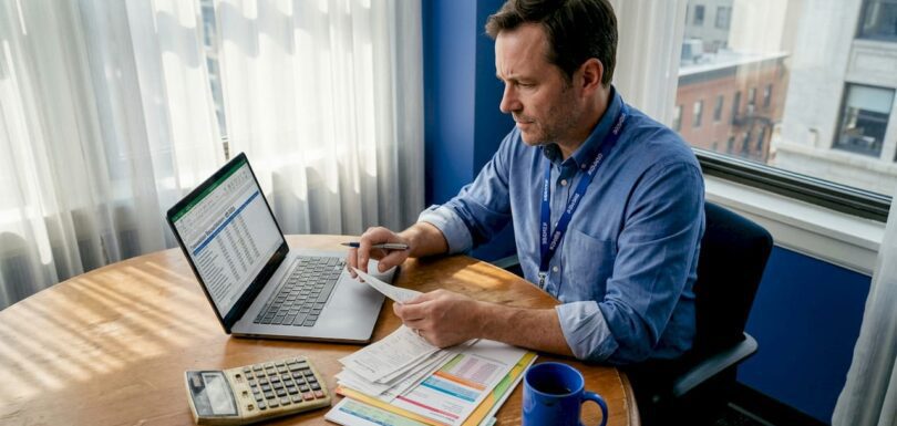 Singapore SME owner reconciling bookkeeping at desk