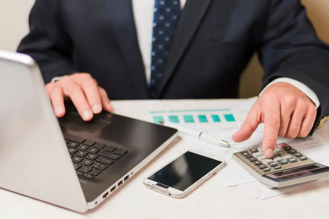 Businessman using calculator 23 2148148347
