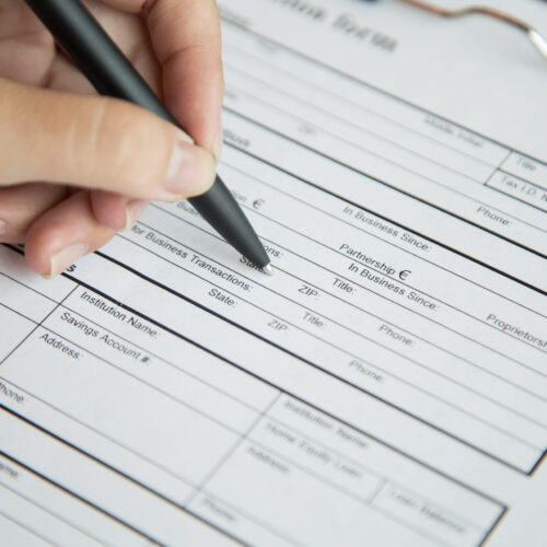 Female candidate filling questionnaire for vacancy Close-up of hand of female candidate filling in questionnaire for vacancy during job interview