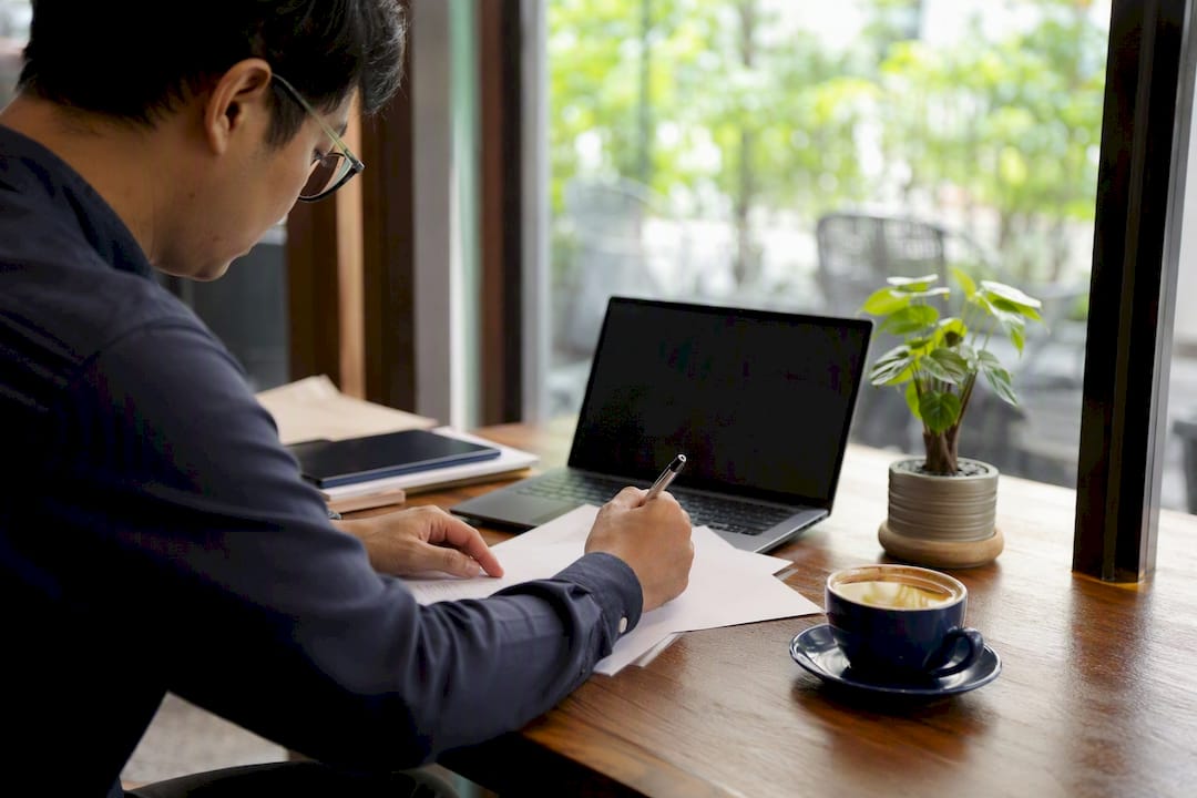 Hands signing business permit documents in Singapore