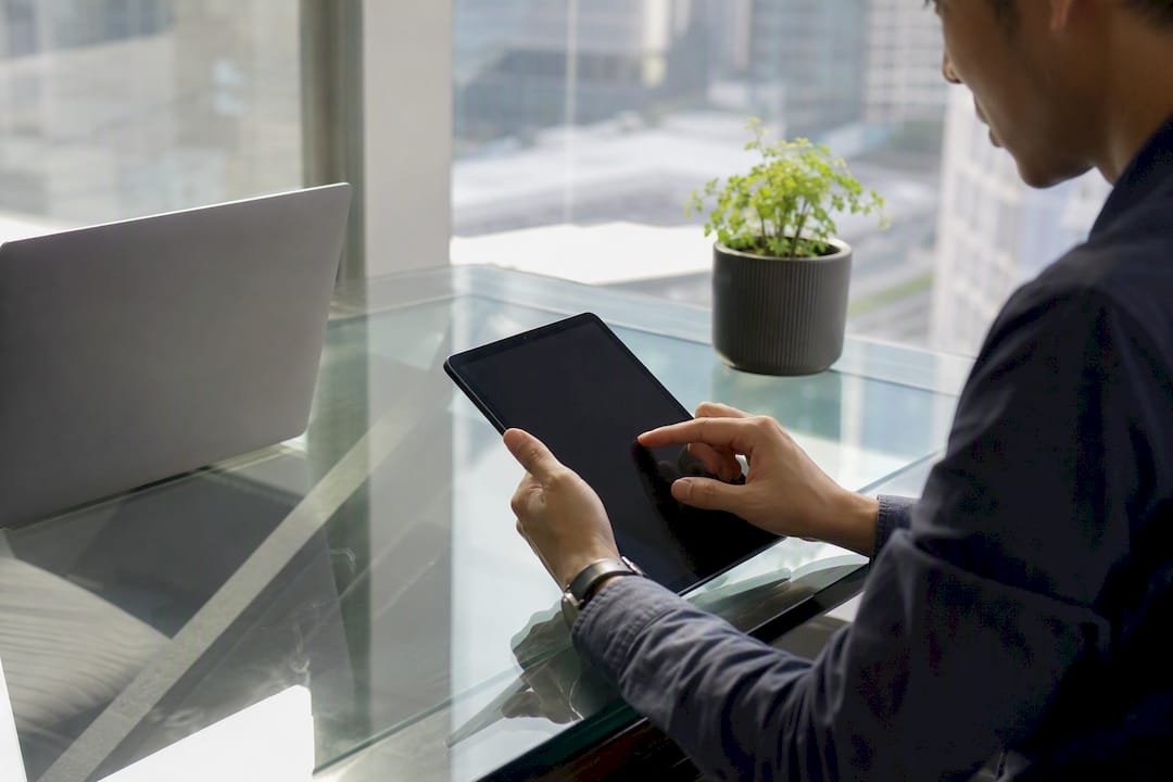 Hands filing corporate tax waiver on tablet in Singapore office