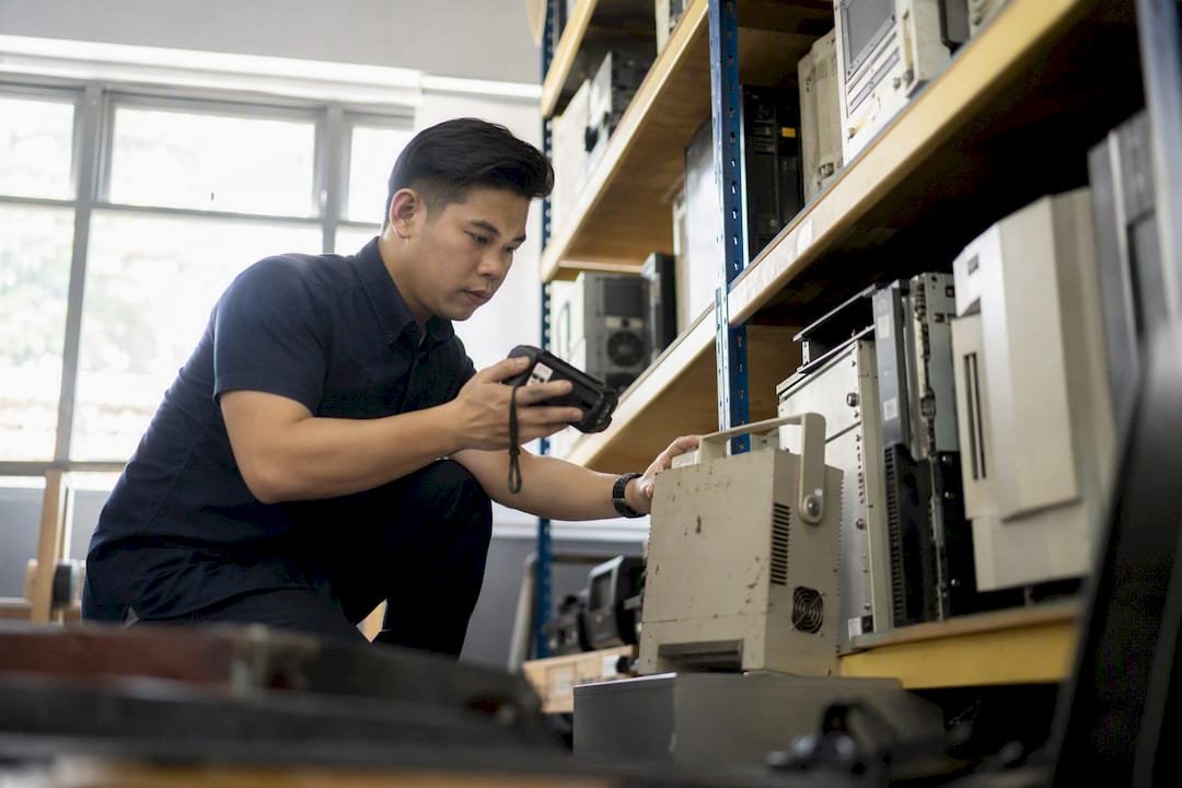 Person checking office equipment asset tags